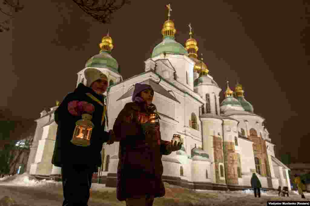 Дівчатка із &laquo;вифлеємським вогнем&raquo; біля Софійського собору у Києві. Україна. 10 грудня 2023 року