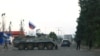 Azerbaijani police patrol next to a Russian peacekeepers' vehicle at a checkpoint along the road leading to the city of Xankendi/Stepanakert, Nagorno-Karabakh, on October 2.