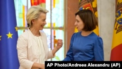 Moldovan President Maia Sandu (right) welcomes European Commission President Ursula von der Leyen during a media conference in Chisinau prior to the start of the European Political Community Summit on May 31.