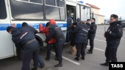 Police detain illegal migrants during a raid at a market in Moscow.