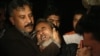A man is comforted by his family as he mourns his brother, who was killed in the blast.