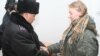 Офицер полиции надевает наручники на осужденную на два года тюрьмы Елизавету Дреничеву. Алматы, 9 января 2009 года. 