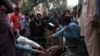 Police collect evidence near the body of Farzana Parveen, who was stoned to death by her relatives in Lahore on May 27.