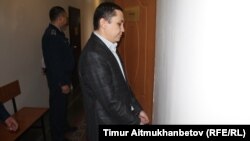 Nurbek Qushaqbaev in handcuffs in a court in Astana on April 7.