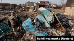 Військовослужбовець ЗСУ оглядає уламки російського бойового літака Су-34 в житловому районі Чернігова, 6 квітня 2022 року