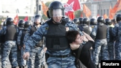 Полицейский тащит участницу демонстрации на Болотной площади. Москва, 6 мая 2012 года.