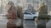 People wait at a bus stop on a cold day in Almaty.
