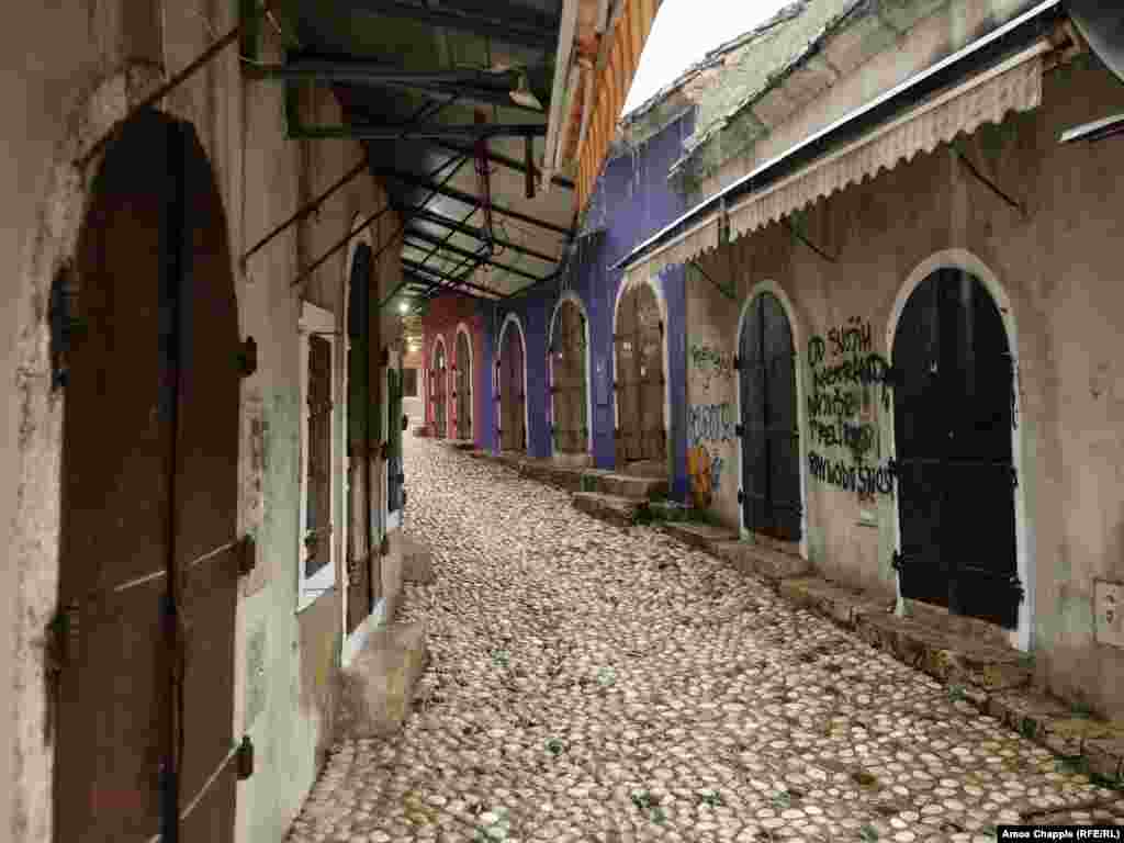 Shuttered stalls next to Mostar’s old bridge in the early afternoon. The graffiti says "Of all my quirks, I most despise indifference." Bosnia’s new government will also be tasked with fixing the enormous damage done to Mostar’s once bustling tourist trade as a result of the COVID pandemic. 