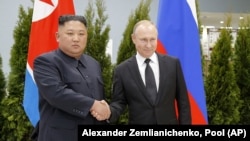 Russian President Vladimir Putin (right) and North Korea's Kim Jong Un shake hands during their meeting in Vladivostok, Russia, in April 2019.