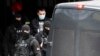 Serbian police escort detained Partizan fan leader Veljko Belivuk (center) during a raid on the Partizan stadium in Belgrade on February 4.