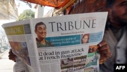 A Pakistani man reads the morning newspaper with front-page-coverage of the attack.