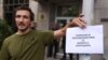 Снимката е илюстративна. На нея протестиращ държи плакат с надпис "Комисия за противодействие на борбата с корупцията" пред сградата на Комисията за противодействие на корупцията в София, 9 юли 2025 г.