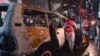 Pakistani volunteers search a destroyed vehicle at the site of a suicide bomb attack at an election campaign rally in Peshawar on April 16.