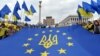 Молодь тримає прапор ЄС з гербом України посередині на майдані Незалежності в Києві, фото архівне