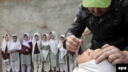 A health worker administers a polio vaccine to a child during a three-day nationwide vaccination campaign to eradicate polio in a heavily Afghan area of Islamabad, Pakistan, on January 21.