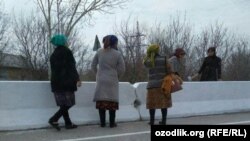 Работники бюджетных организаций в Каттакурганском районе Самаркандской области занимаются побелкой бетонных барьеров на магистральной дороге. Фото Радио Озодлик.