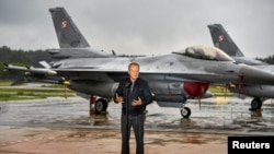 Полскиот премиер Доналд Туск стои пред борбените авиони Ф-16 на полските воздухопловни сили додека држи прес-конференција во врска со заканата од руски беспилотни летала во полскиот воздушен простор во 32-та тактичка воздухопловна база во Ласк.