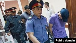 Полиция хезмәткәрләре җинаятьтә гаепләнүчеләрне мәхкәмә утырышына алып килә. 6 июнь 2013