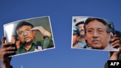 A supporter of former military ruler Pervez Musharraf holds up posters bearing his image during a rally in Islamabad on January 15.