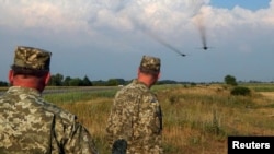Ukrainian servicemen watch Sukhoi Su-24 front-line bombers fly during military aviation drills as Russia accuses Ukraine in incursion into annexed Crimea, in Rivne region, August 10, 2016
