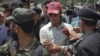 Pakistani police escort one of the two men they said were suspected to be dancing in the footage of a wedding as he leaves after appearing before the Supreme Court in Islamabad on June 6.