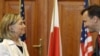 Хиллари Клинтон менен Радослав Сикорски кол коюлган документтерди алмашууда. 