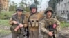 Wagner chief Yevgeny Prigozhin poses with two of his mercenaries as he makes a statement about withdrawing his forces from the embattled Ukrainian city of Bakhmut on May 25. 