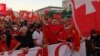 Protesters in Podgorica wave national flags to protest the use of Serbian national symbols by opposition parties that preliminary results show won elections last week.