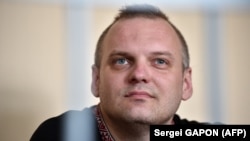 Dzmitry Halko looks on as he sits in the defendants' cage during his trial in Minsk on July 17. 